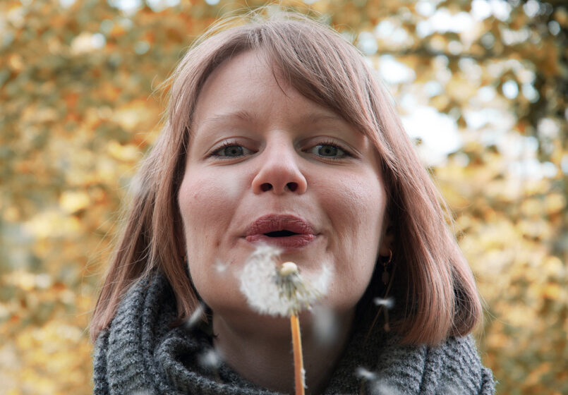 Jiyanh pustet in der Natur eine Pusteblume.