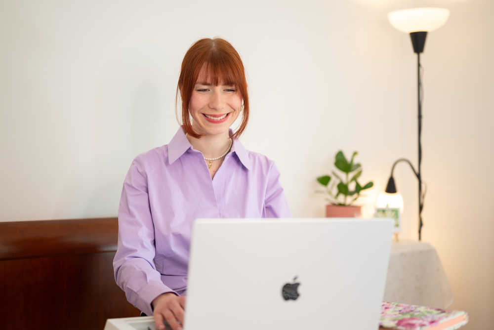 La'inesh arbeitet freudig am Laptop von Apple.