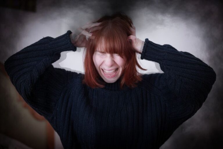 Wütende Frau, die sich die Haare rauft.